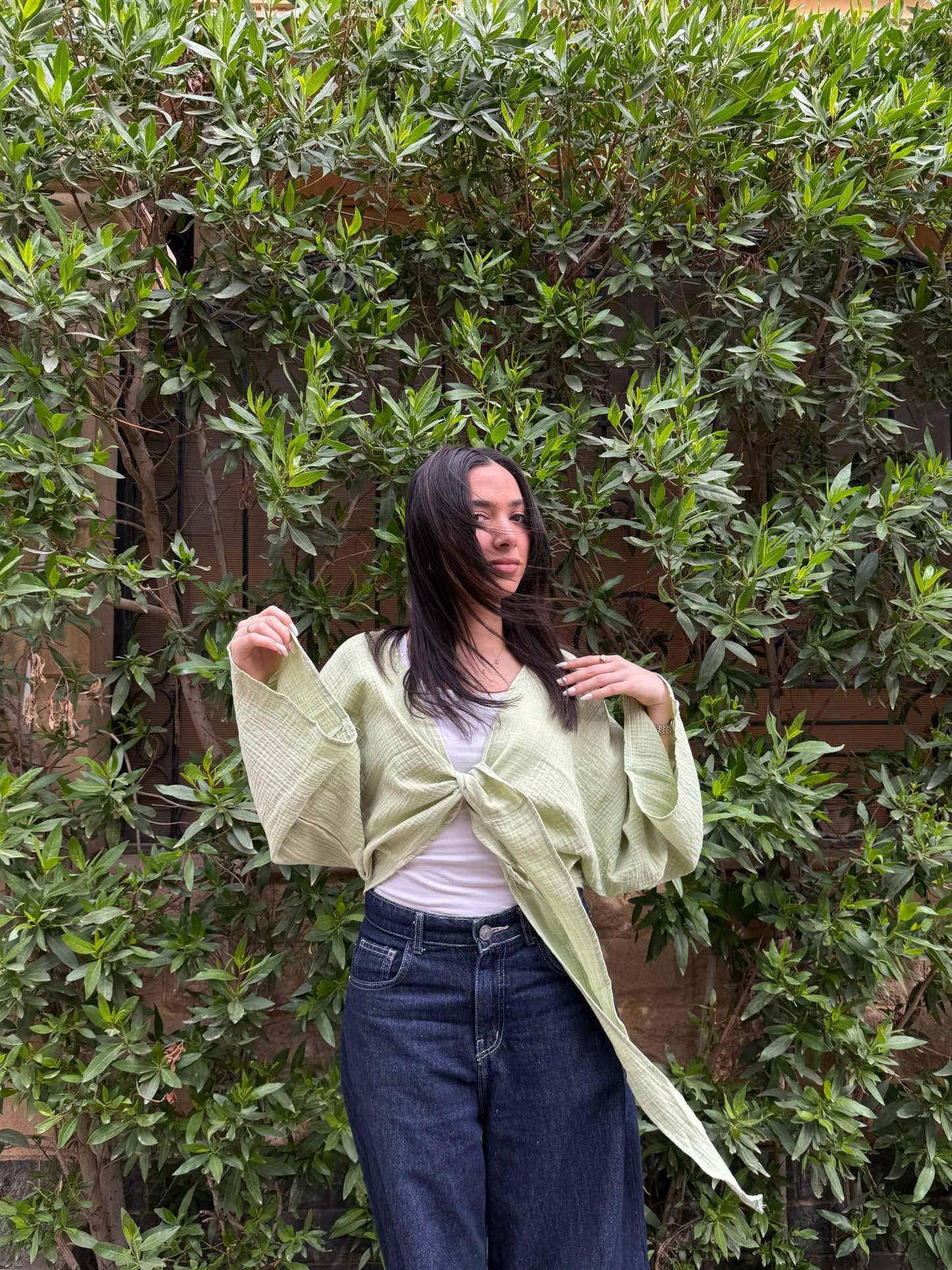 Ocean Breeze Cardigan – sage green textured tie-front cardigan with flowy relaxed sleeves, styled with dark denim for a light effortless casual look.